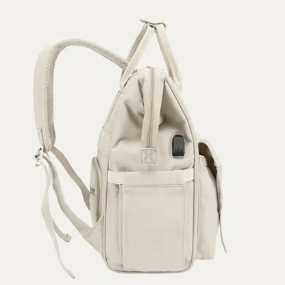 Beige backpack with multiple pockets on a light gray background
