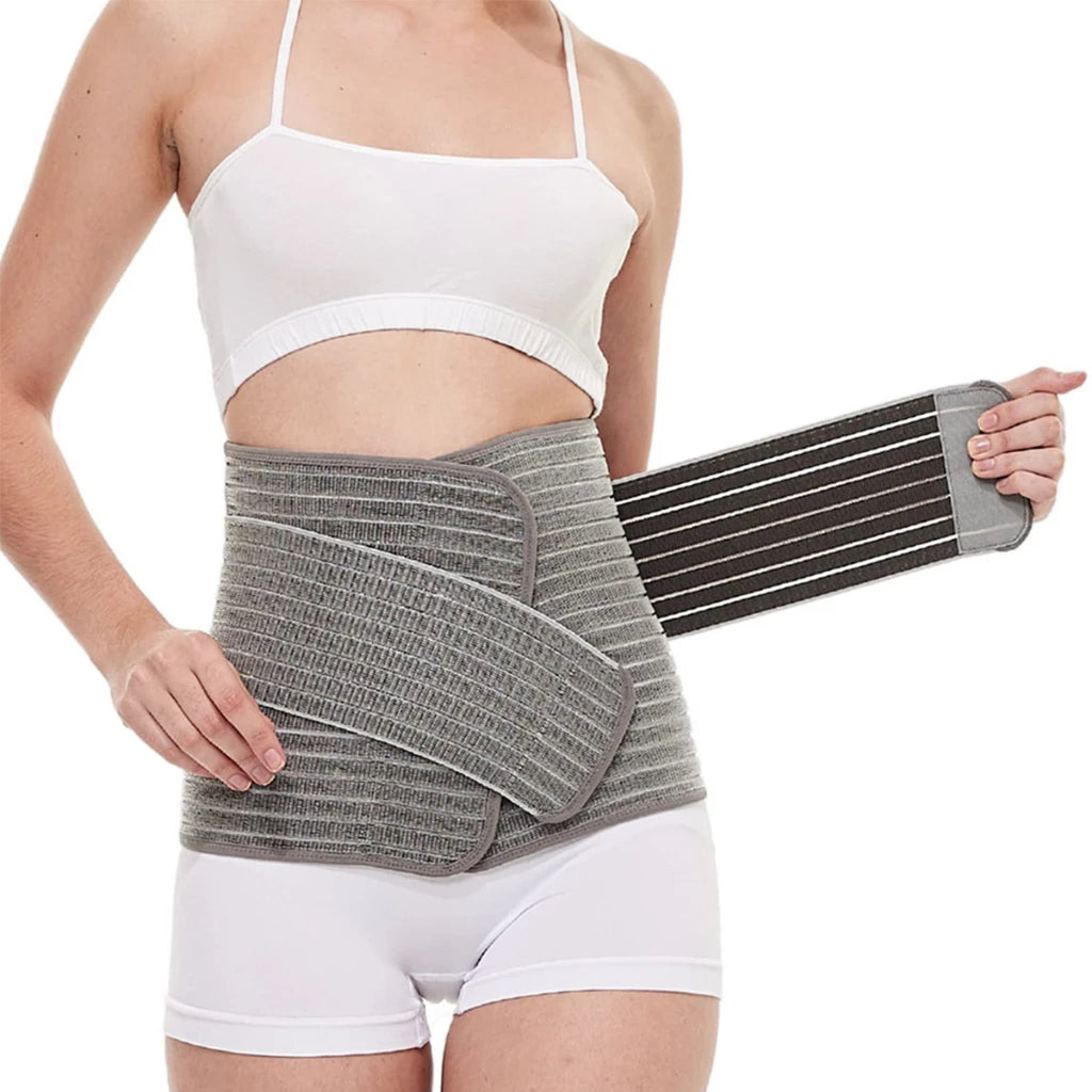 Person wearing a gray compression wrap on their waist against a white background