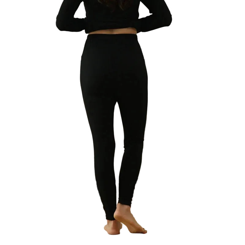 Person wearing black leggings standing in a white background