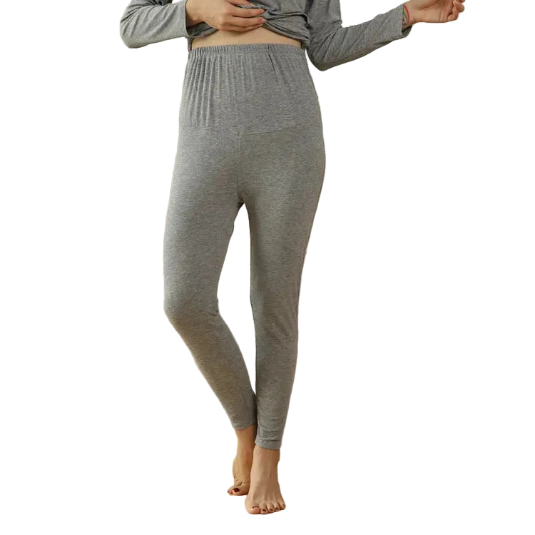 Person wearing gray lounge pants standing in a living room with a beige sofa.