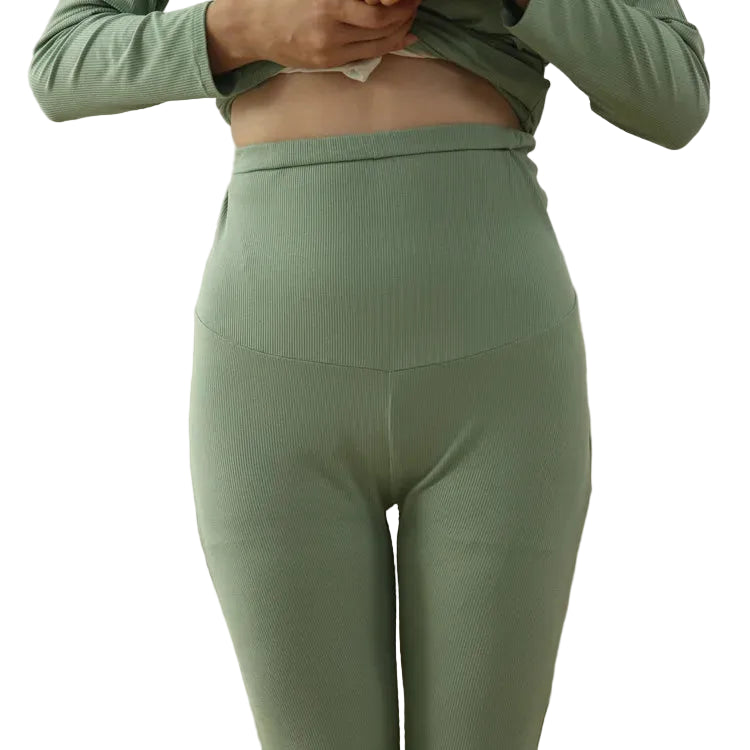 person wearing green ribbed leggings and top in a room with a couch and chair.