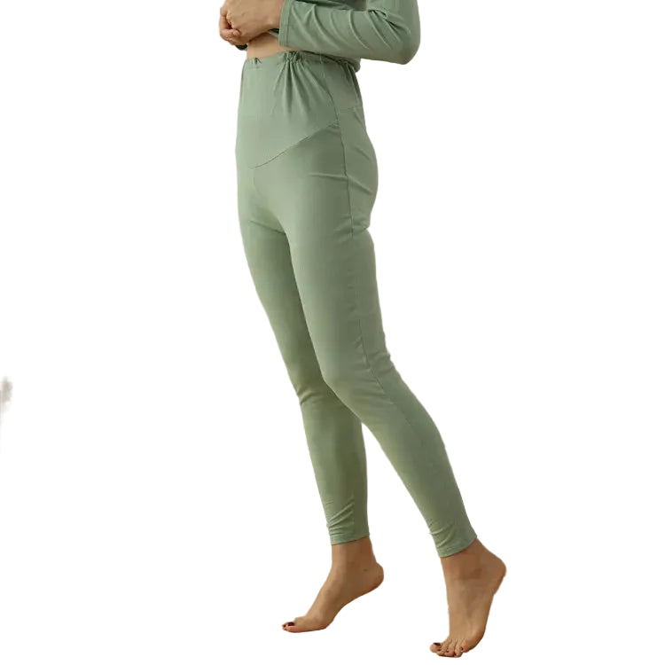 Person wearing a green outfit standing in a white background